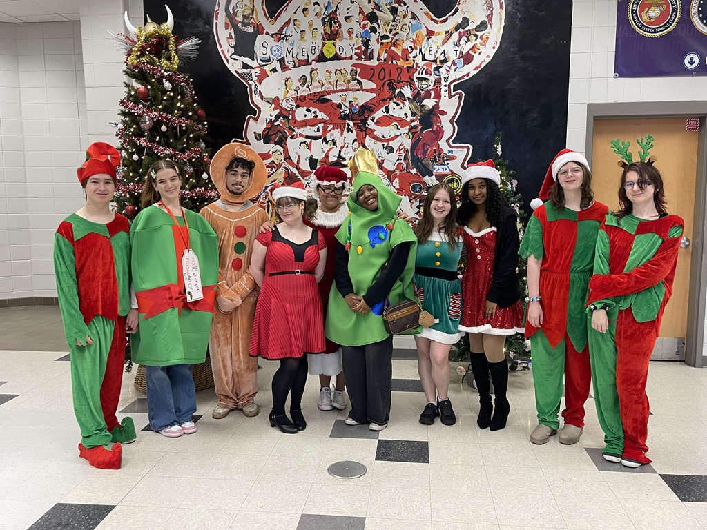 High school students dressed as elves, presents, gingerbread man, Christmas tree, and Mrs. Claus