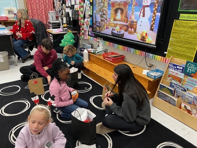 High school student reading book with elementary student