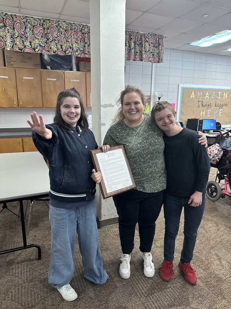 Teacher with 2 students holding proclamation