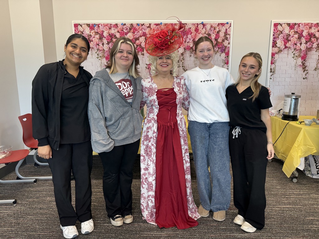 Mrs. Tuten in Victorian dress and hat with four students