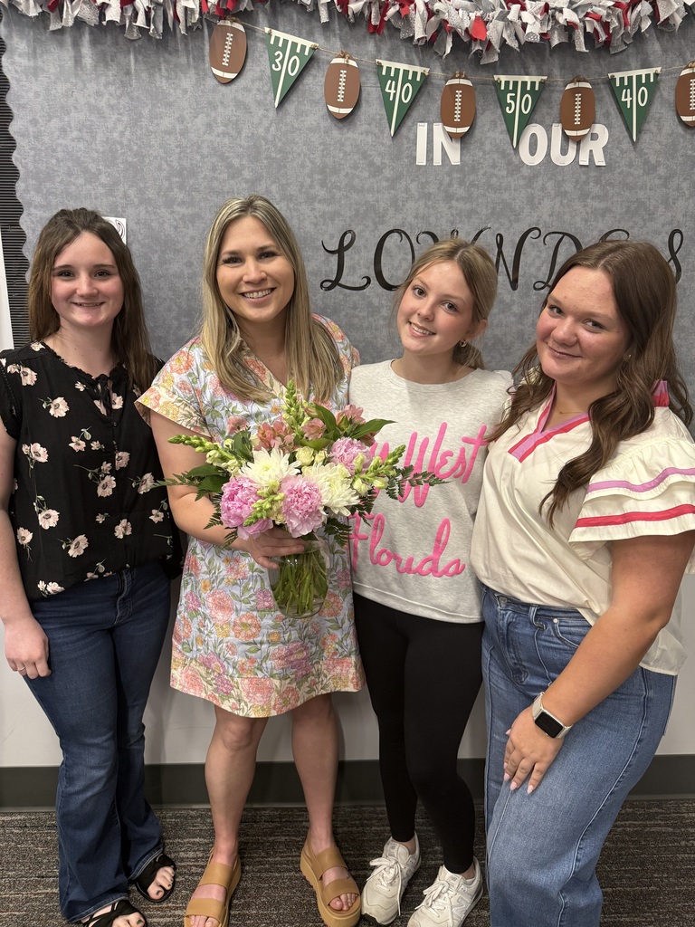 FFA students presenting a floral arrangement to Ms. Beall