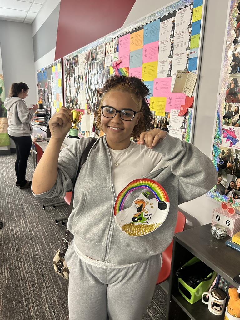 Student with small gold trophy and artwork