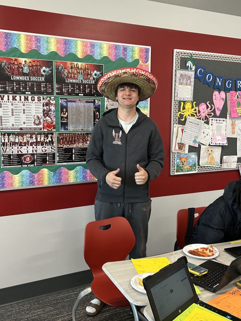 Student giving two thumbs up in a sombrero
