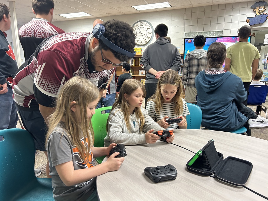 eSports member watching elementary students play a game