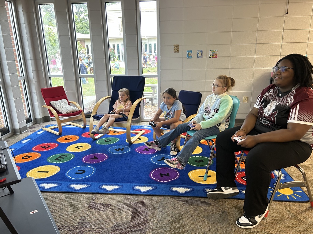 eSports member playing a game with elementary students