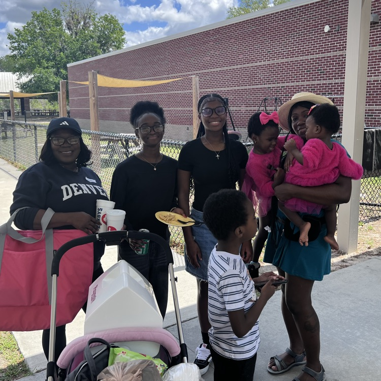 families eating lunch outside 