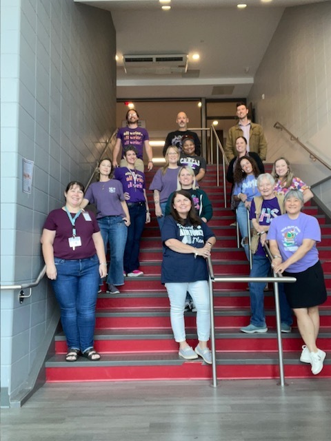 English teachers dressed in purple on the stairs