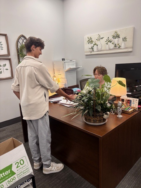 Student delivering gift to an administrative assistant