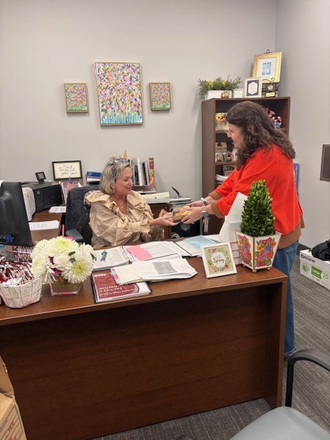 Teacher delivering gift to administrative assistant
