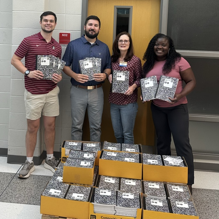 admin, teacher, and Walmart employee posing with composition books