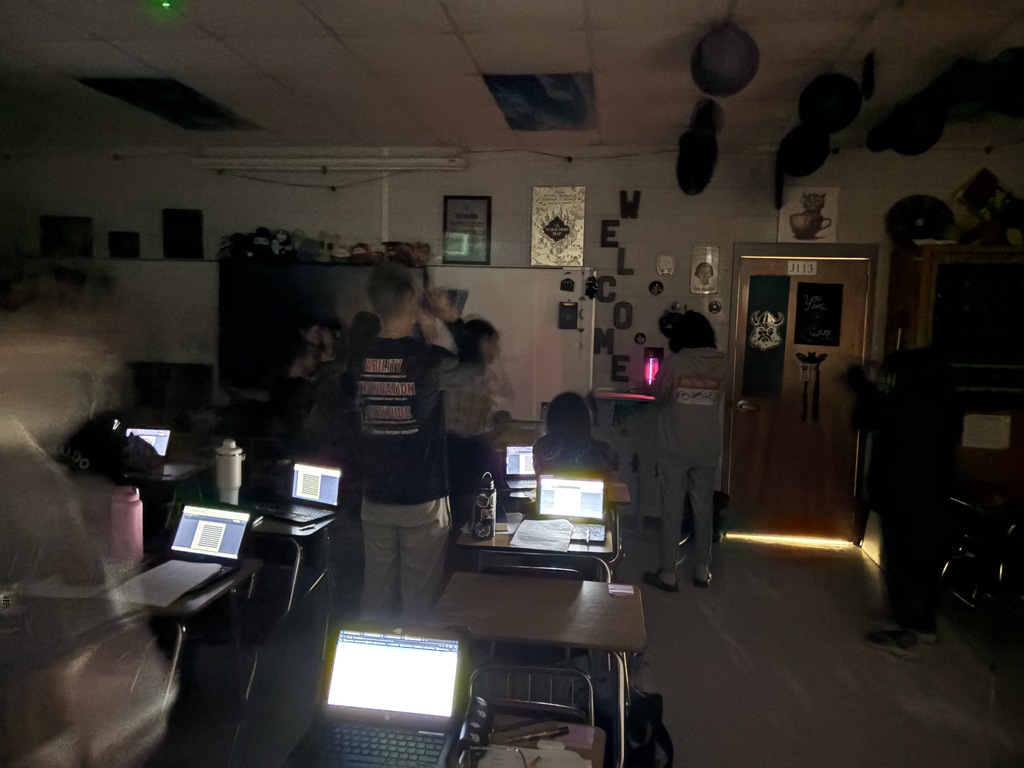 Astronomy students using spectrometry to identify mystery gases in glowing tubes.