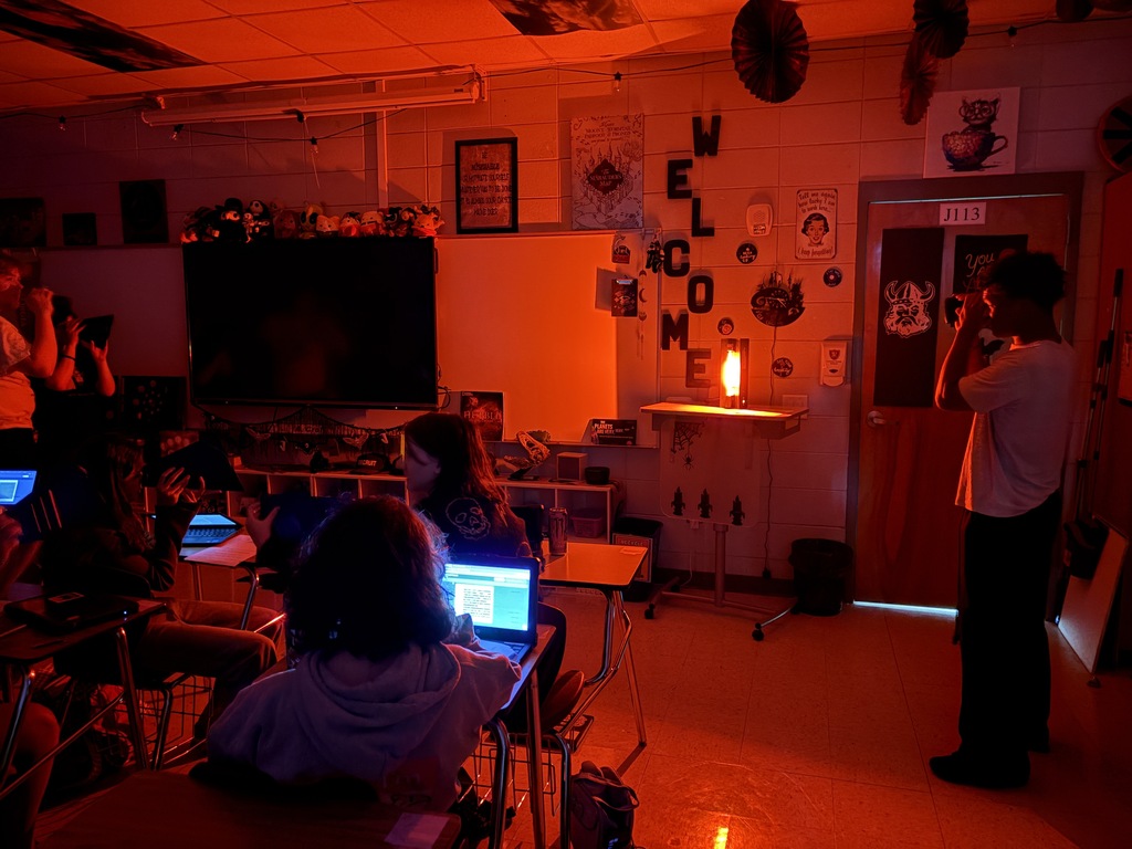 Astronomy students using spectrometry to identify mystery gases in glowing tubes.