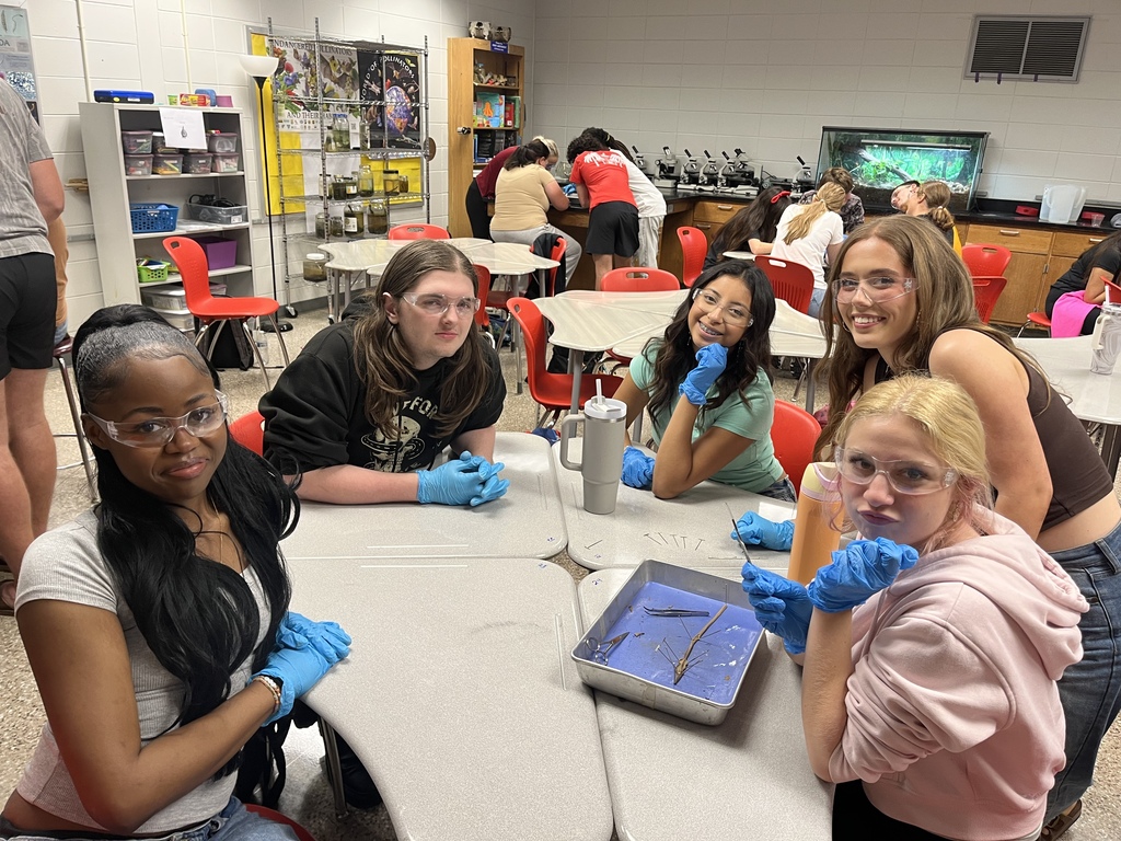 Zoology students in goggles and gloves dissecting an earthworm
