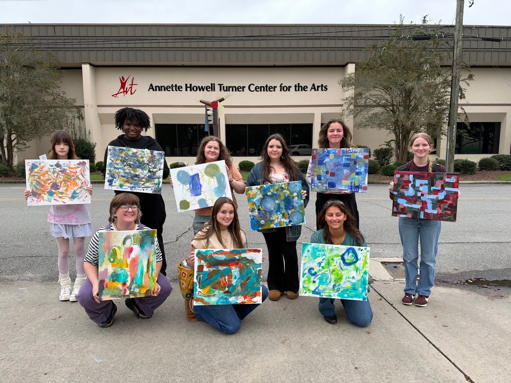 Students with their paintings in front of the Annette Howell Turner Center for the Arts
