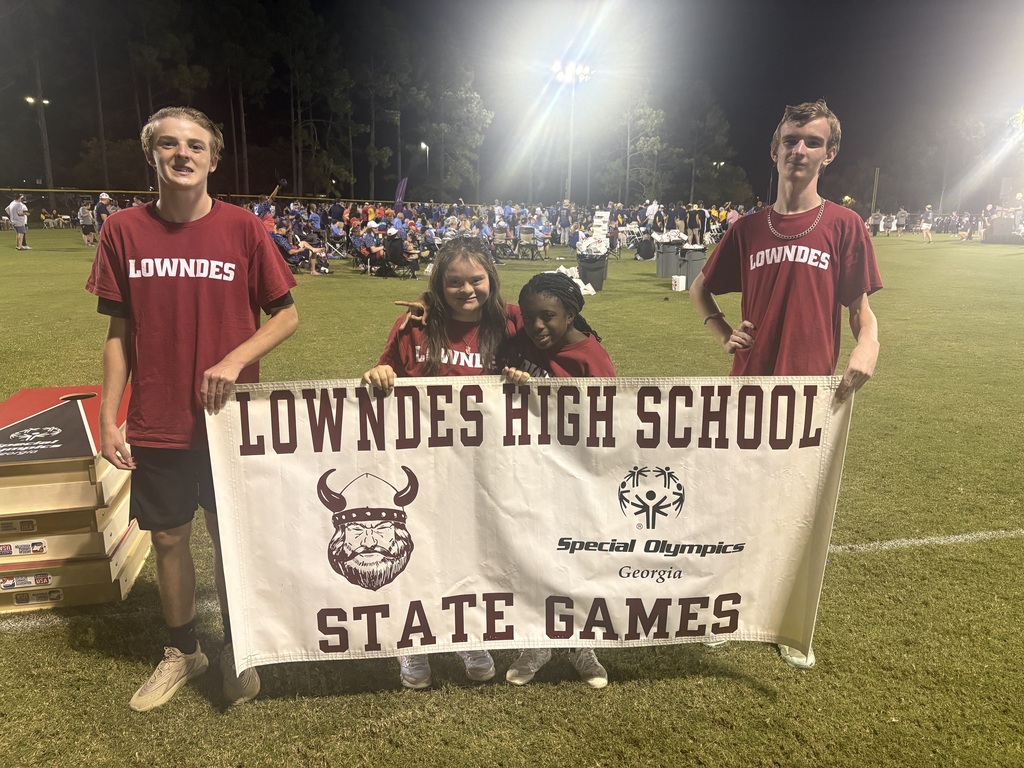 Four students carrying the Lowndes High School banner