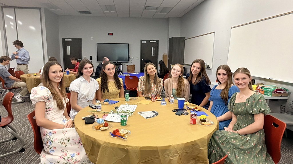 A table with 8 NEHS members at the ceremony