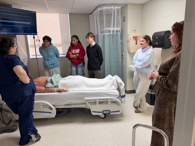 Students in a hospital room learning about the procedures