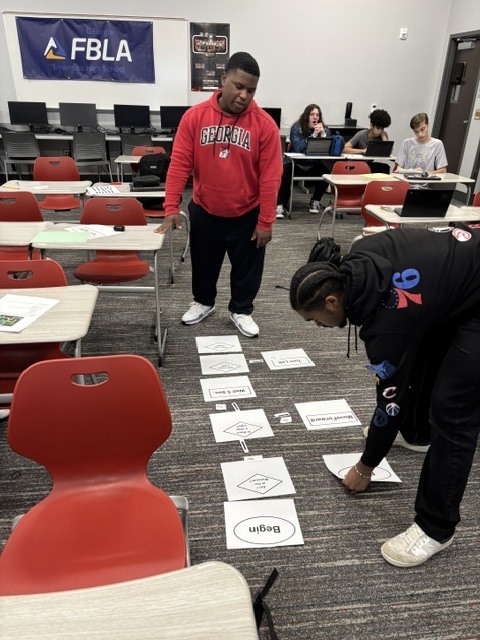 Students analyzing algorithms and flow charting