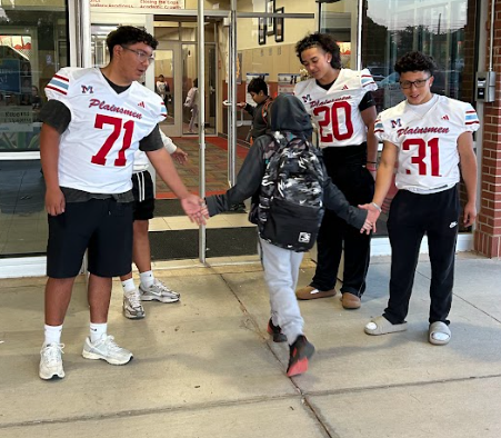 football players greeting students