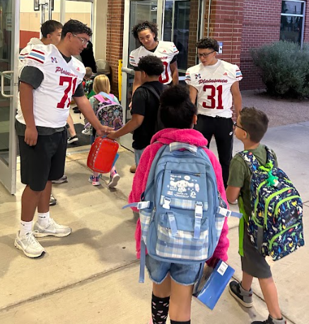 football players greeting students
