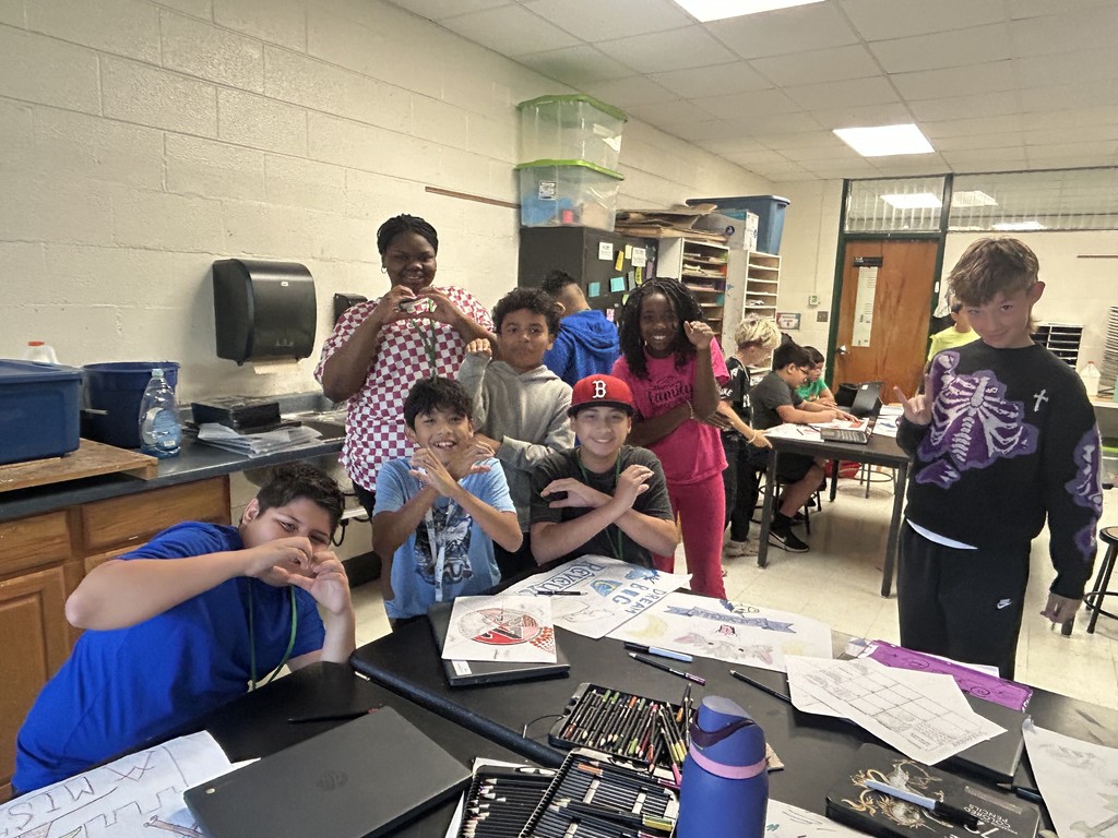 students  posing with artwork