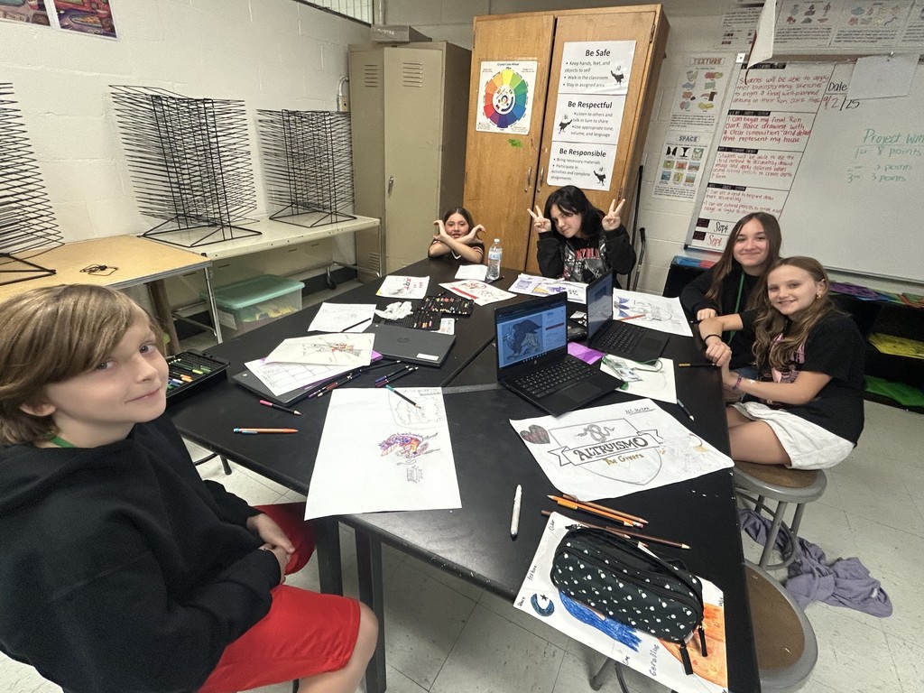students  posing with artwork