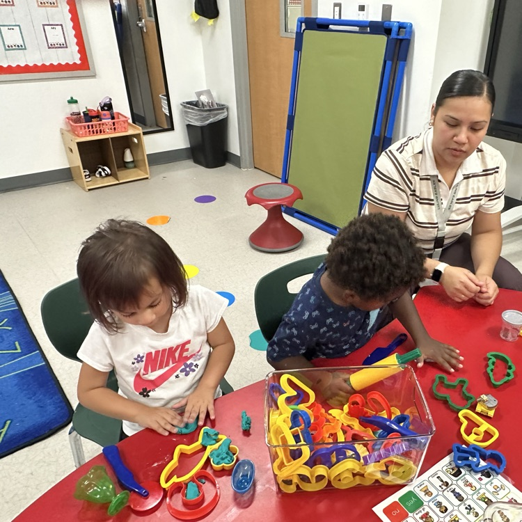 students using rolling pins and cookie cutters with playdough