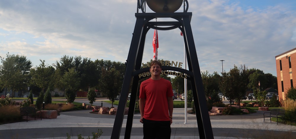 Tyler Hodge next to bell