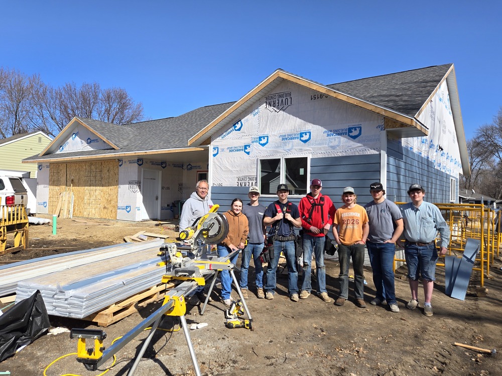 TnT class members pose in front of house