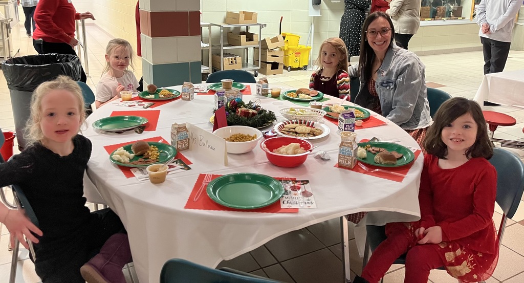 Students and parents eating Respect lunch at round tables.