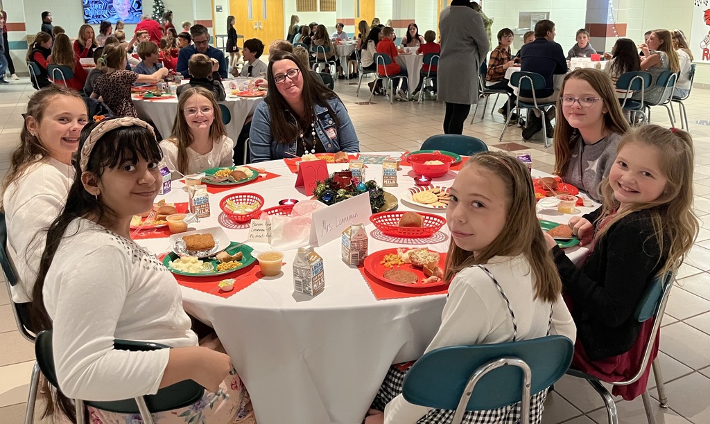 Students and parents eating Respect lunch at round tables.