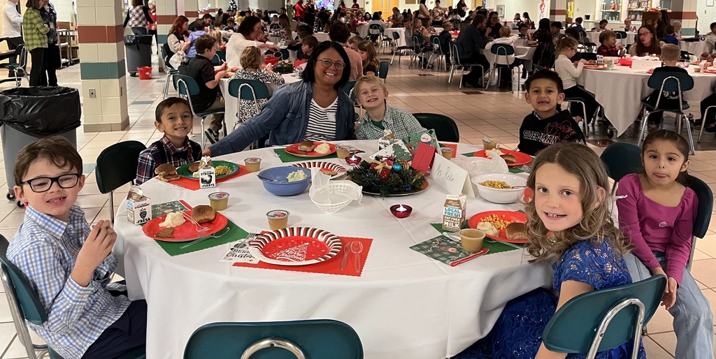 Students and parents eating Respect lunch at round tables.
