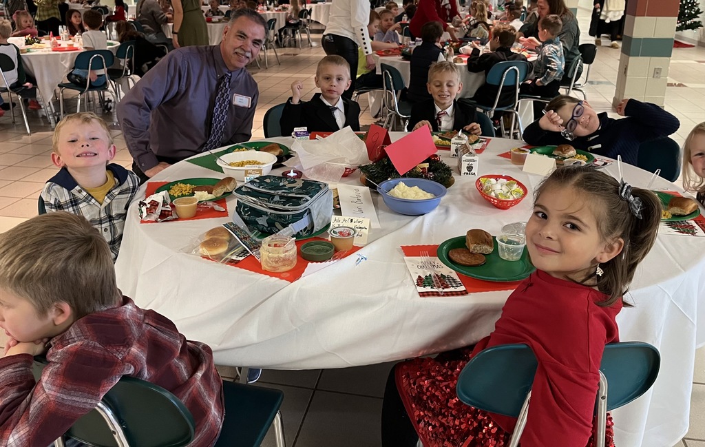 Students and parents eating Respect lunch at round tables.