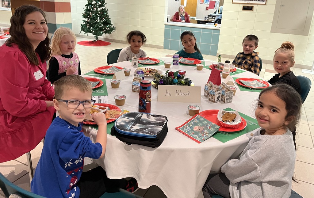 Students and parents eating Respect lunch at round tables.