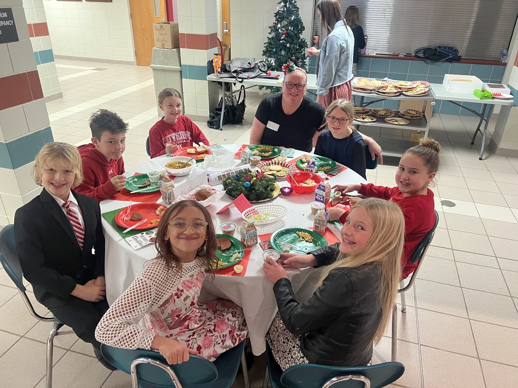 Students and parents eating Respect lunch at round tables.