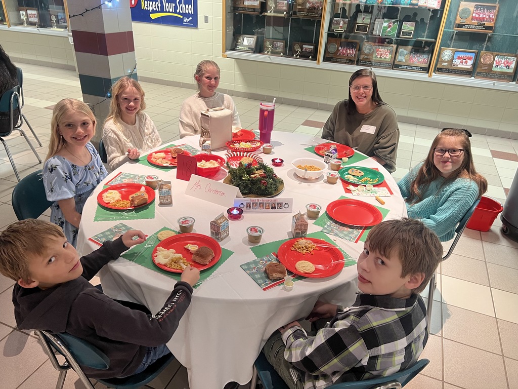 Students and parents eating Respect lunch at round tables.