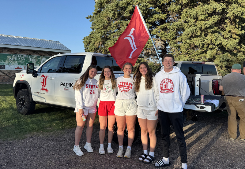 students pose in front of truck holding donated food