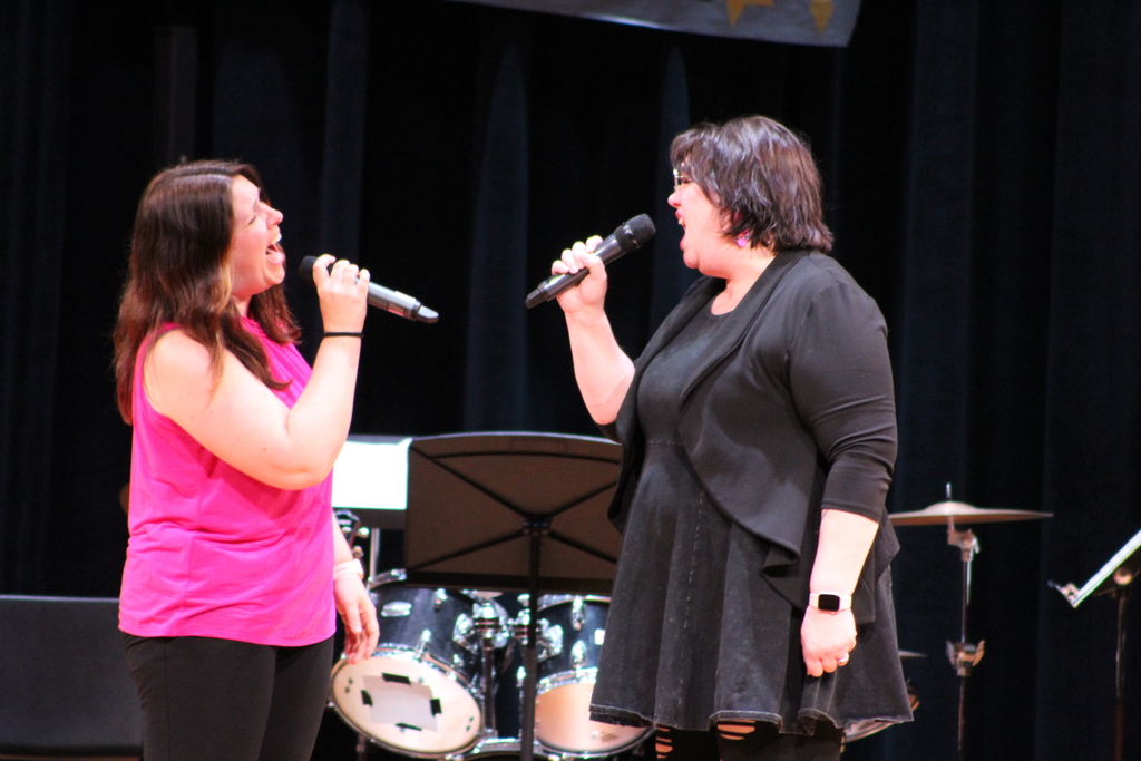 two women singing a duet on stage