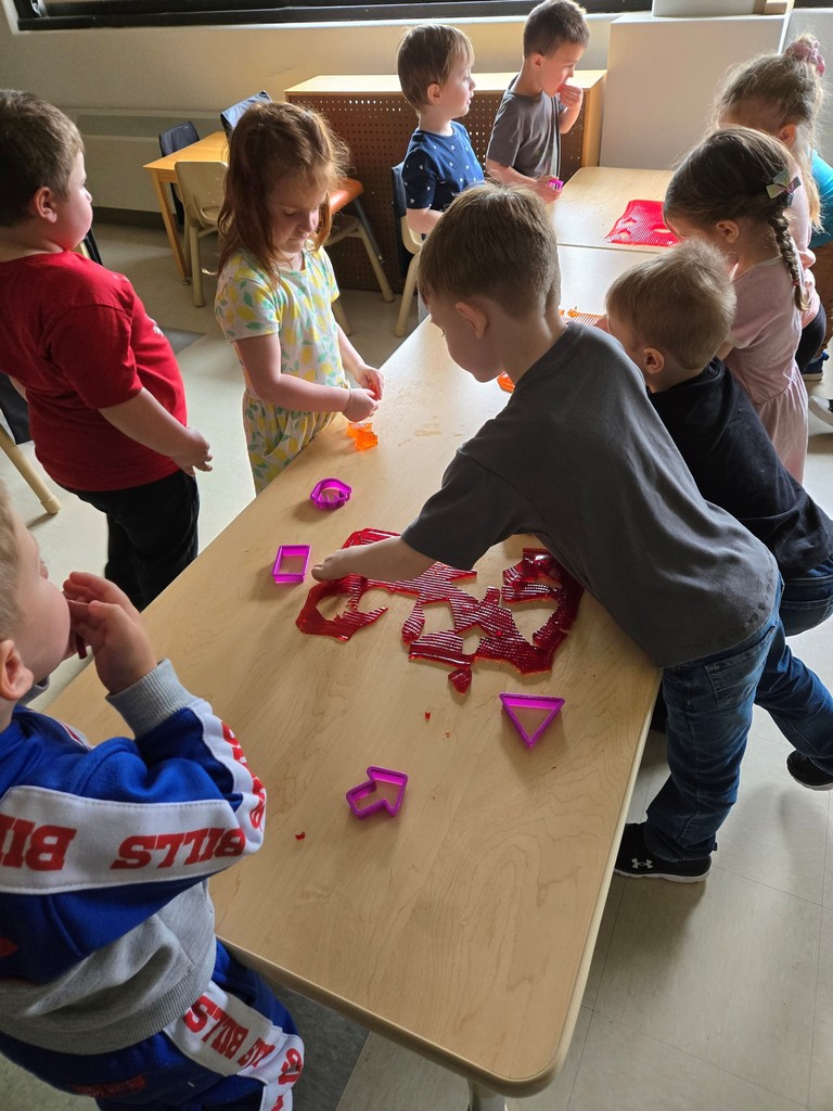 students standing around table cutting shapes out of jello