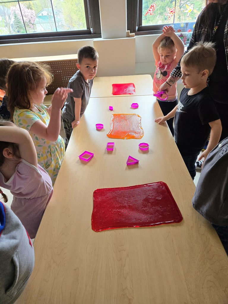 students standing around table preparing to cutt shapes out of jello