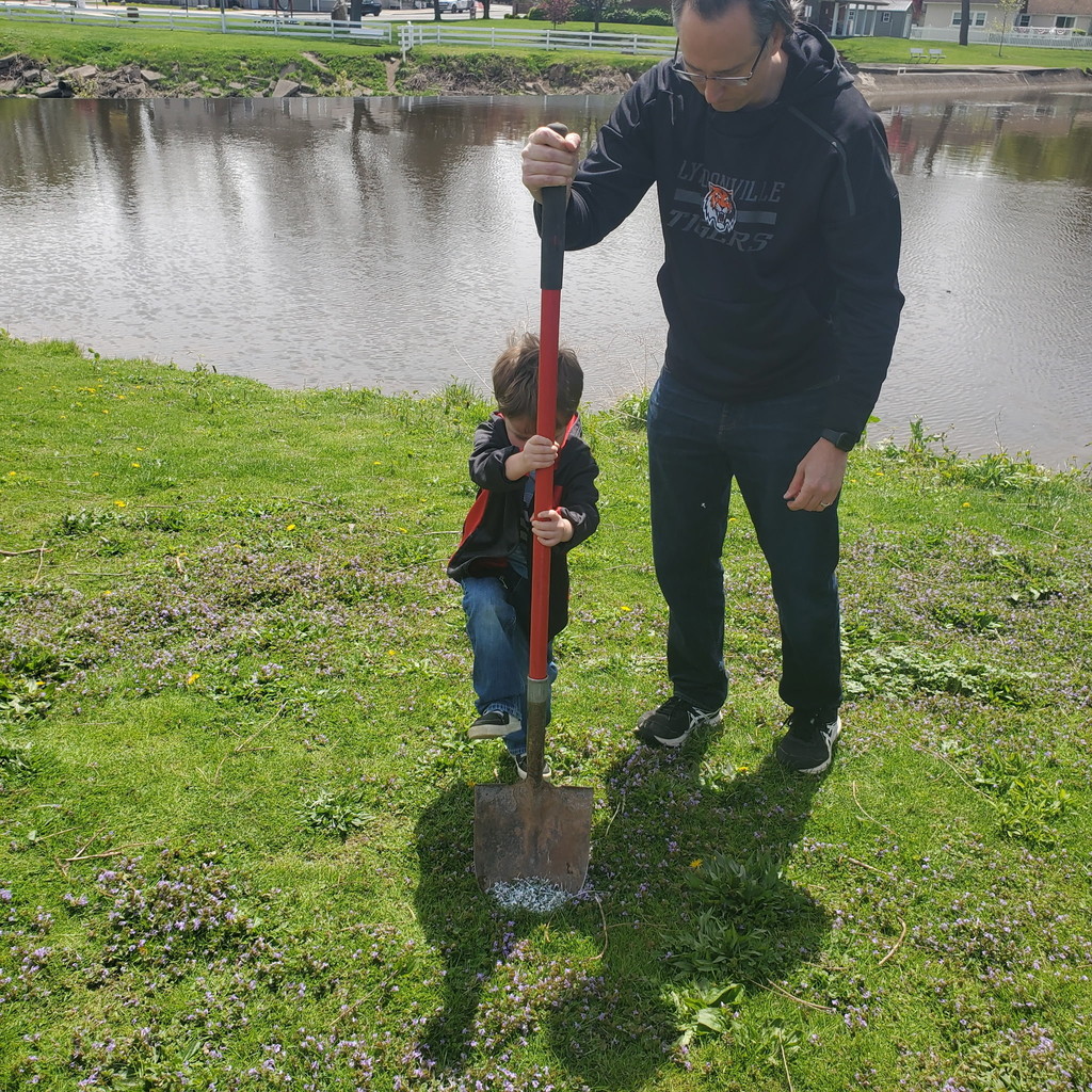 student and teacher trying to break ground with shovel