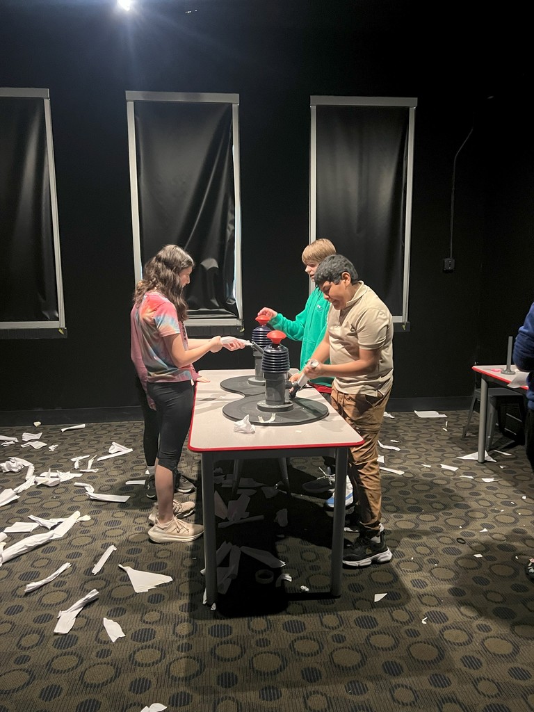 students working at a table in the museum
