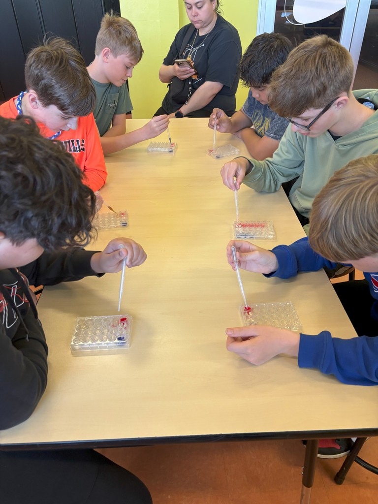 students working at a table on science experiment
