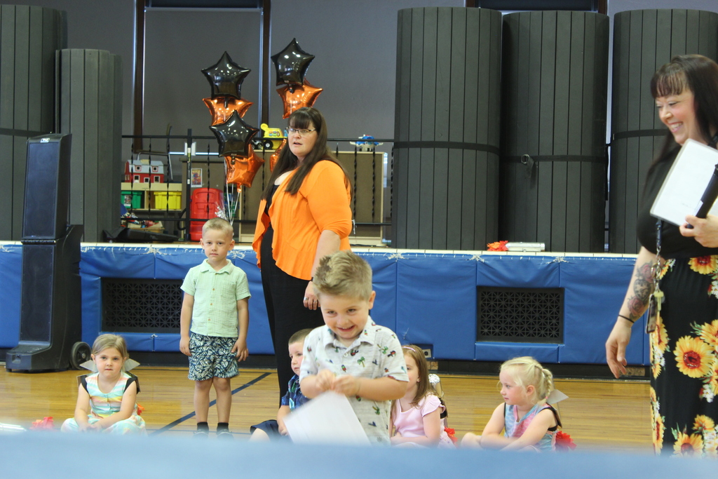 boy holding certificate standing in gym