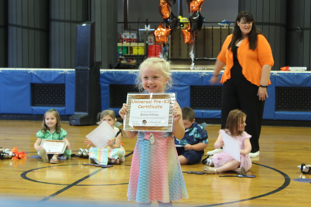girl holding certificate standing in gym