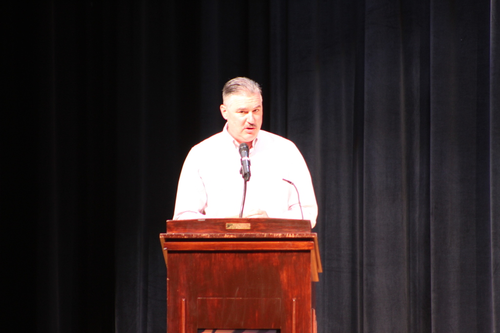 principal speaking at lectern