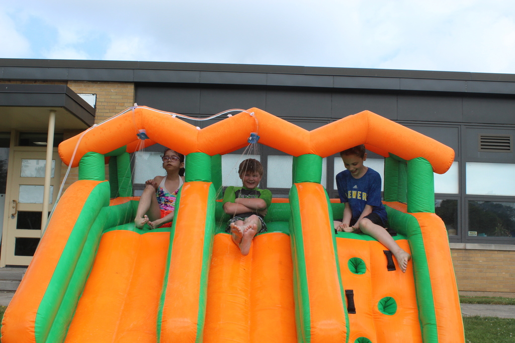 three students at top of inflatable slide