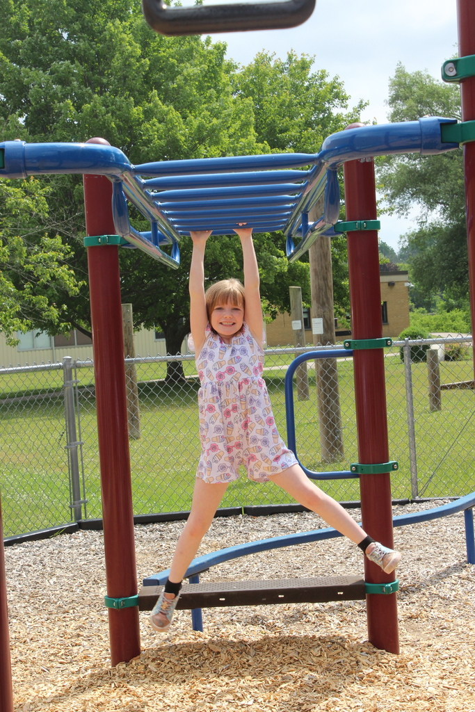 girl on monkey bars on playground