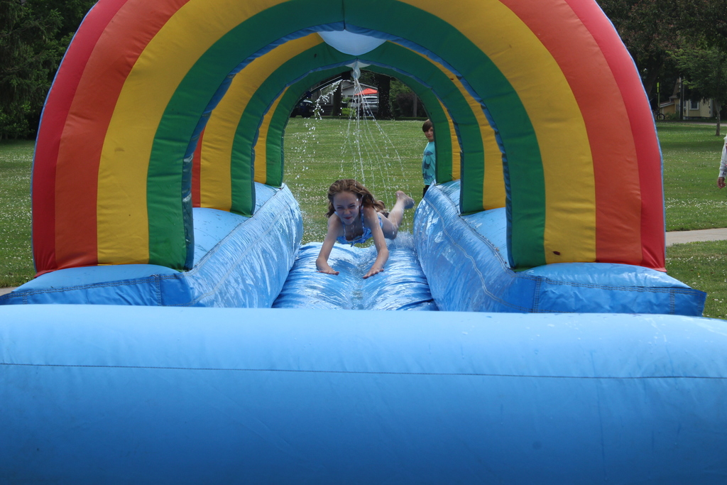girl sliding through rainbow water slide