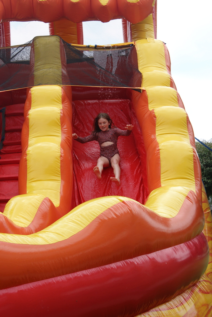 girl sliding down inflatable water slide